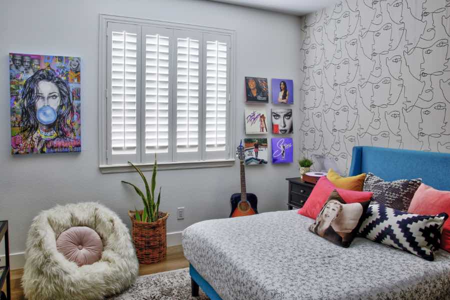 White Polywood shutters on a window in a trendy teen bedroom.